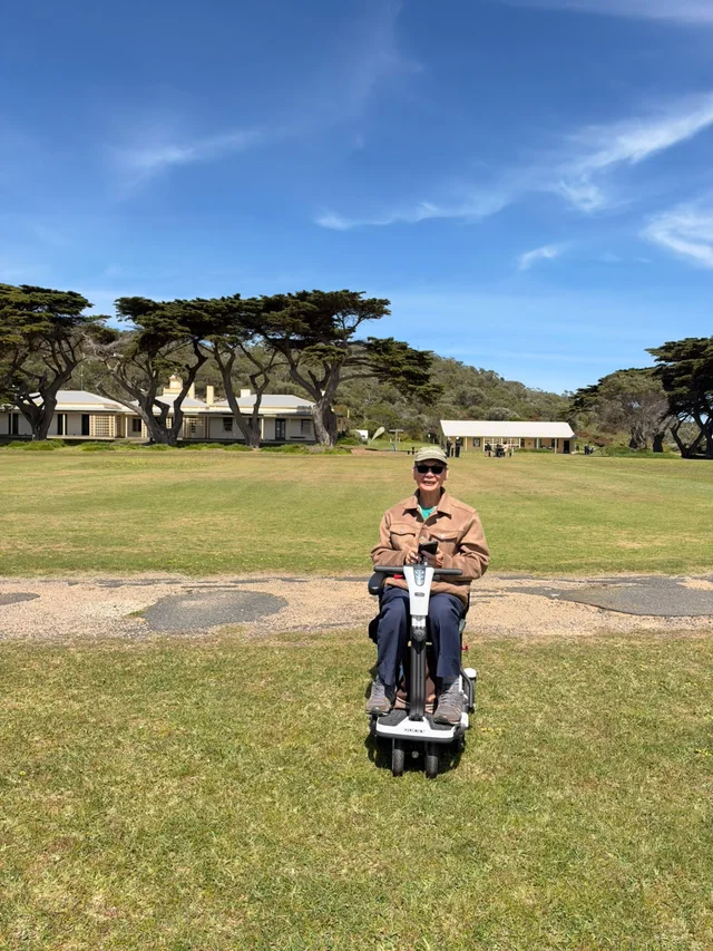 A community member enjoying the grassy foreshore on a mobility scooter